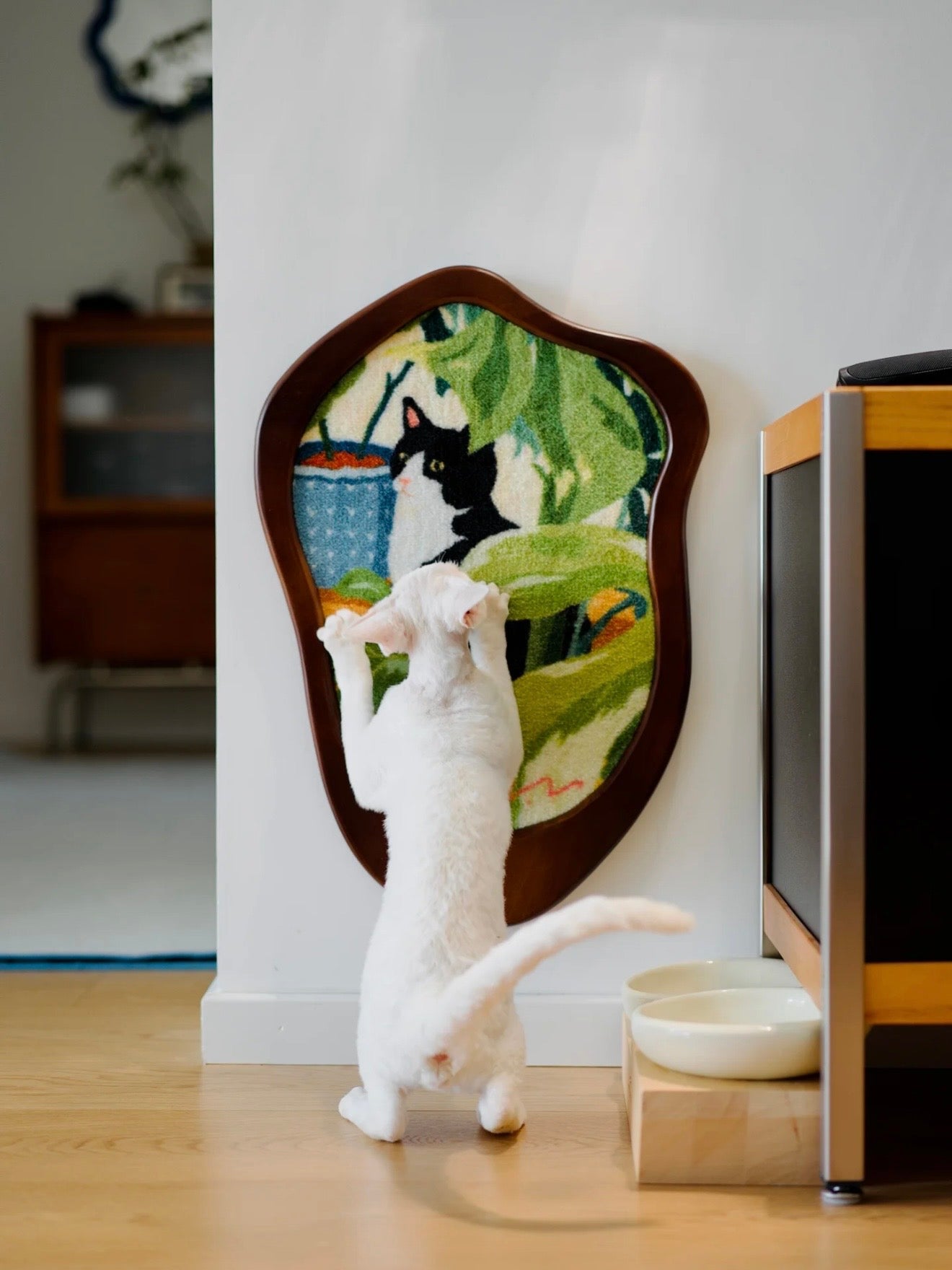 White cat scratching the Cats and Plants Art Print Cat Scratcher on a wall