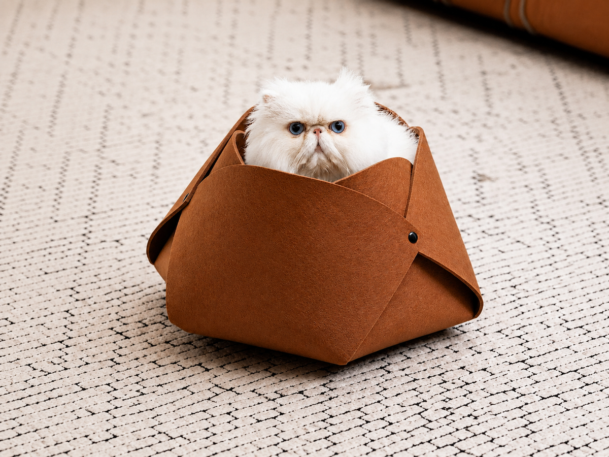 White Persian cat resting inside a caramel felt flower cave bed